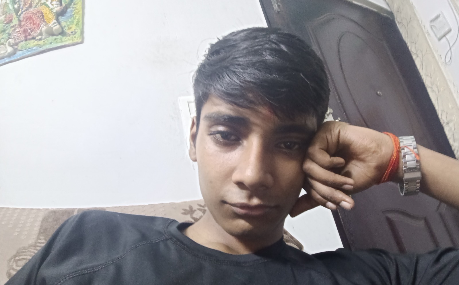 Aryan Srivastav, founder of Arise AI, in a black t-shirt resting his head on his hand, wearing a steel wristwatch.